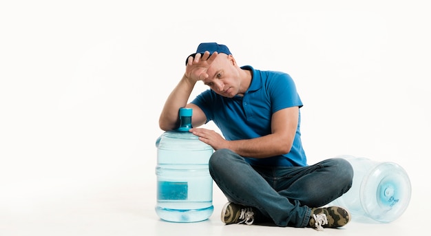 Müder Lieferbote mit Wasserflasche und Kopienraum