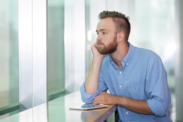 Müder Manager am Fenster im Büro