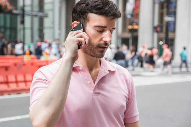 Müder Mann, der über Smartphone spricht