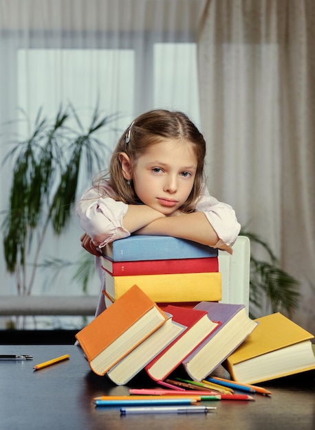 Müdes kleines Mädchen, nachdem es viele Bücher studiert und gelesen hat.