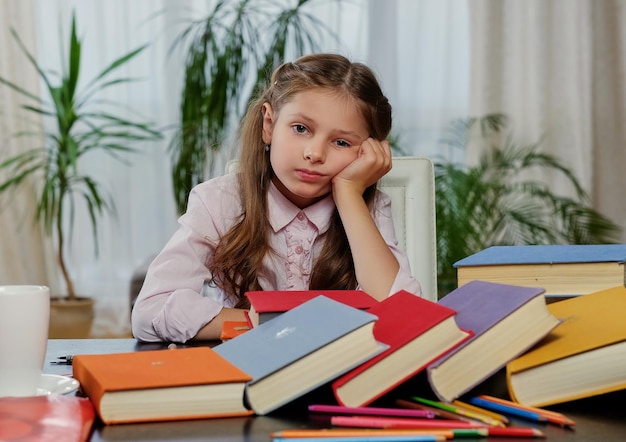 Müdes kleines Mädchen, nachdem es viele Bücher studiert und gelesen hat.