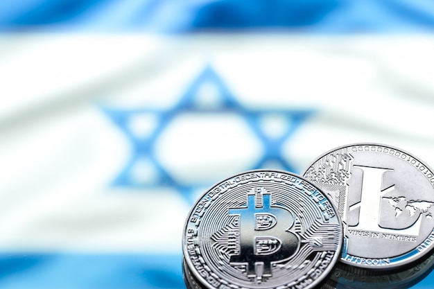 Münzen Bitcoin und Litecoin, vor dem Hintergrund der israelischen Flagge, Konzept des virtuellen Geldes, Nahaufnahme. Konzeptionelles Bild