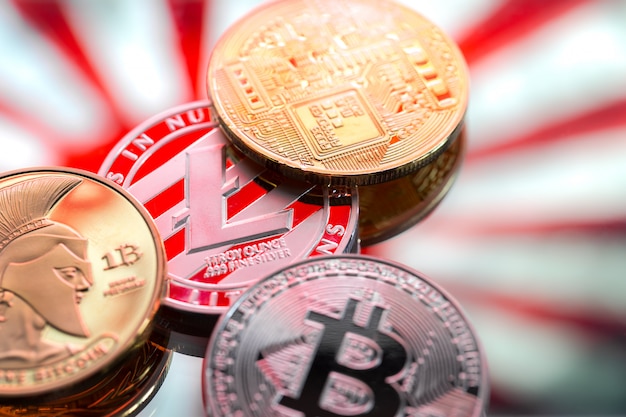 Münzen Litecoin und Bitcoin, vor dem Hintergrund Japans und der japanischen Flagge, das Konzept des virtuellen Geldes, Nahaufnahme.