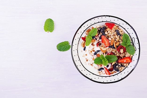 Kostenloses Foto müsli, erdbeeren, kirsche, geißblattbeere, nüsse und joghurt in einer schüssel