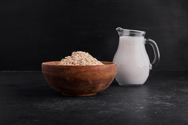 Müsli in einer holzschale serviert mit einem glas milch.