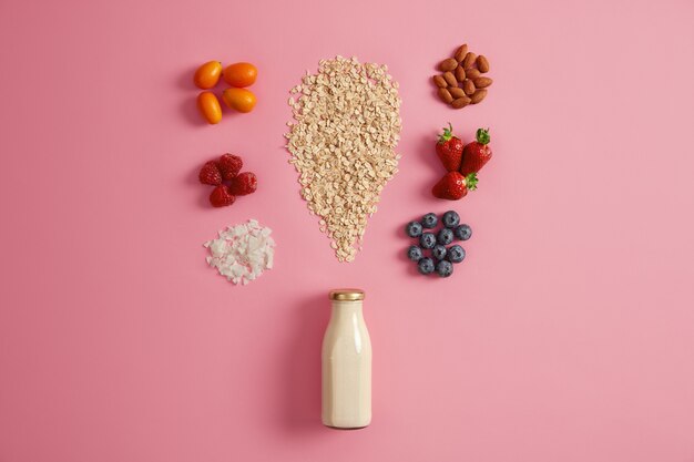 Müsli mit getrockneten Äpfeln, Datteln, Cashewnüssen, Pistazien um die Flasche mit Milch