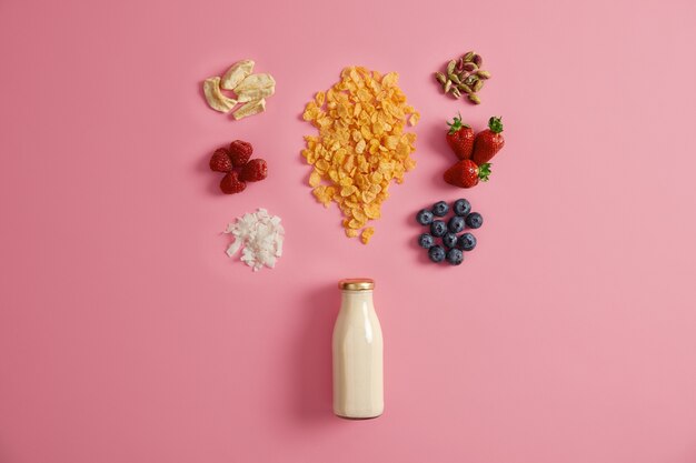 Müsli mit getrockneten Äpfeln, Datteln, Cashewnüssen, Pistazien um die Flasche mit Milch