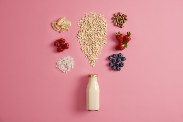 Müsli mit getrockneten Äpfeln, Datteln, Cashewnüssen, Pistazien um die Flasche mit Milch