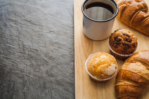 Muffins und Kaffee auf Holzbrett