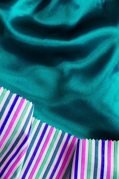 Multi farbiges Gewebematerial auf seidigem grünem Textilhintergrund