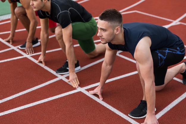 Multiethnische Athletengruppe bereit zu laufen