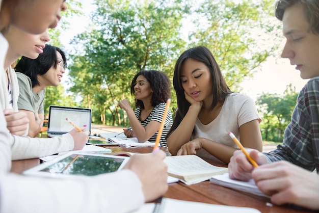 Multiethnische Gruppe junger Studenten, die sitzen und studieren