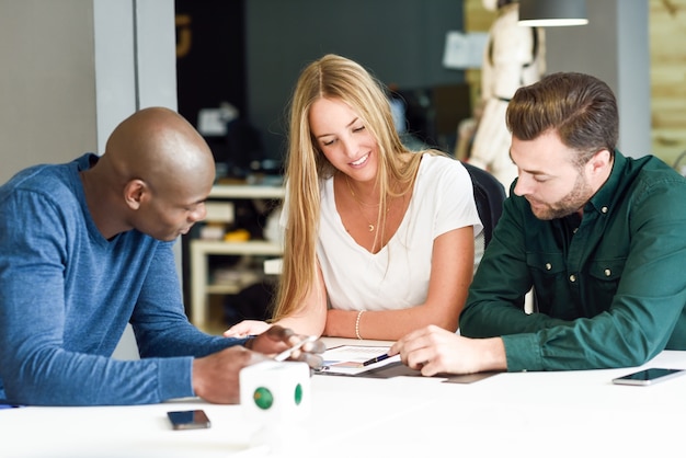 Multiethnische Gruppe von drei jungen Menschen, die zusammen studieren