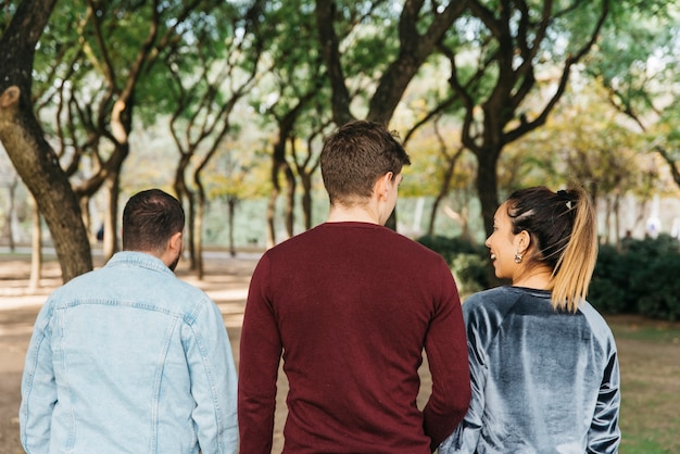 Multiethnische lächelnde Freunde, die in Park gehen und Spaß haben