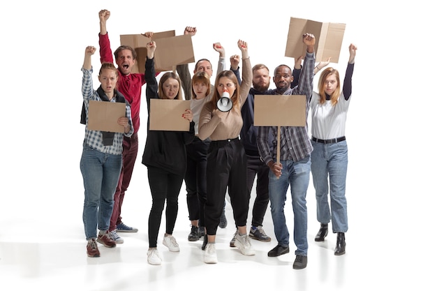 Multikulturelle Gruppe von Menschen, die schreien, während sie leere Plakate an der weißen Wand halten