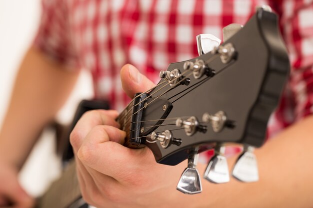 Musik, Nahaufnahme. Musiker, der eine hölzerne Gitarre anhält