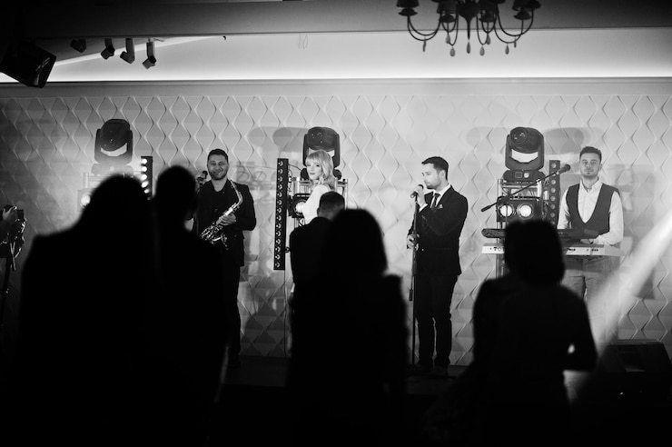Kostenlose Foto musikalische musik-live-band, die auf einer bühne mit verschiedenen lichtern mit einer menge fans auftritt