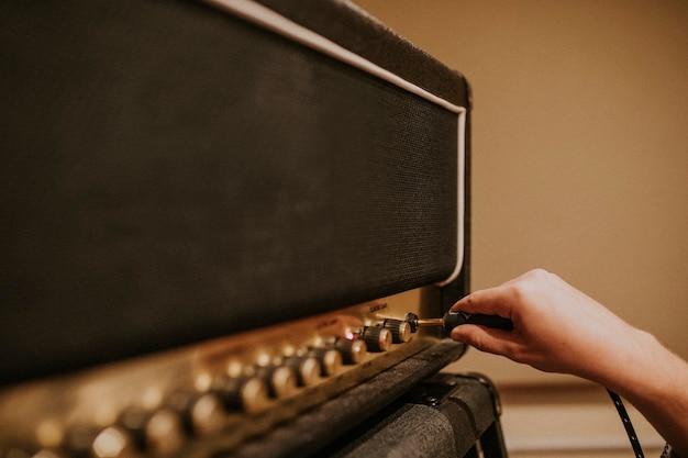 Kostenloses Foto musiker, der gitarrenverstärker einstellt, studioaufnahmesitzungsfoto