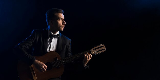 Musiker Mann mit Fliege spielt klassische Gitarre