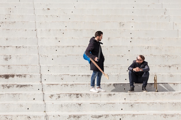 Musiker sprechen auf Betontreppen