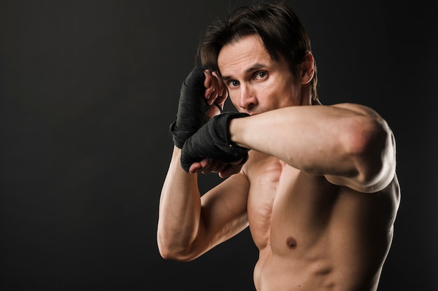 Muskulöser hemdloser Mann mit Boxhandschuhen