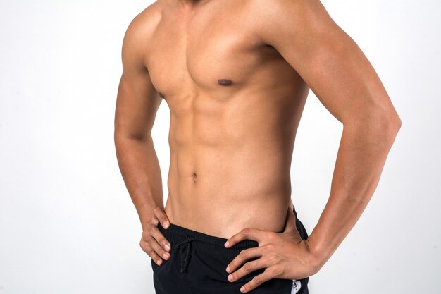 Muskulöser Mann, der sechs Satz-ABS lokalisiert auf weißem Hintergrund zeigt.