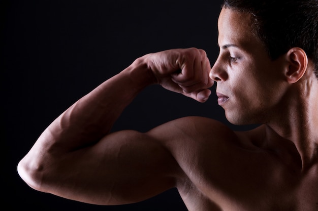 Muskulöser Mann zeigt seinen starken Bizeps