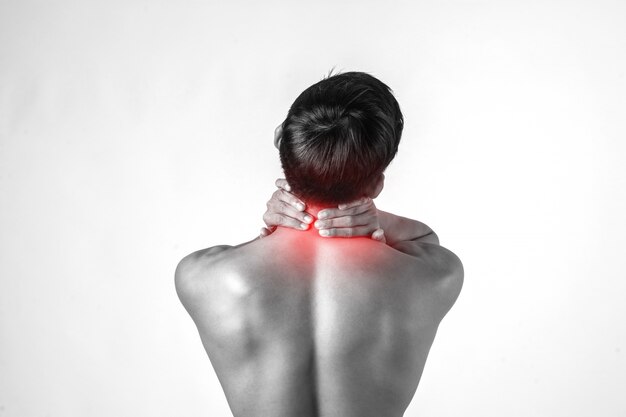 Muskulöser Manngebrauch behandelt am Hals, um die Schmerz zu entlasten, die auf weißem Hintergrund lokalisiert werden.