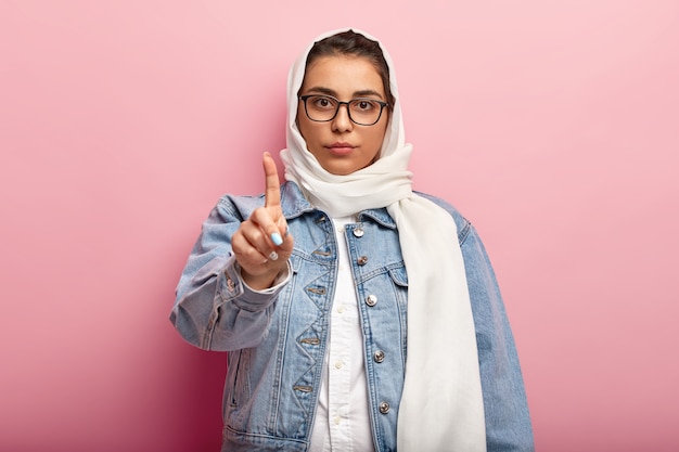 Muslimische Frau, die Jeansjacke trägt