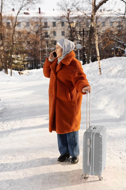 Kostenloses Foto muslimische frau mit hijab, die im urlaub auf dem smartphone spricht