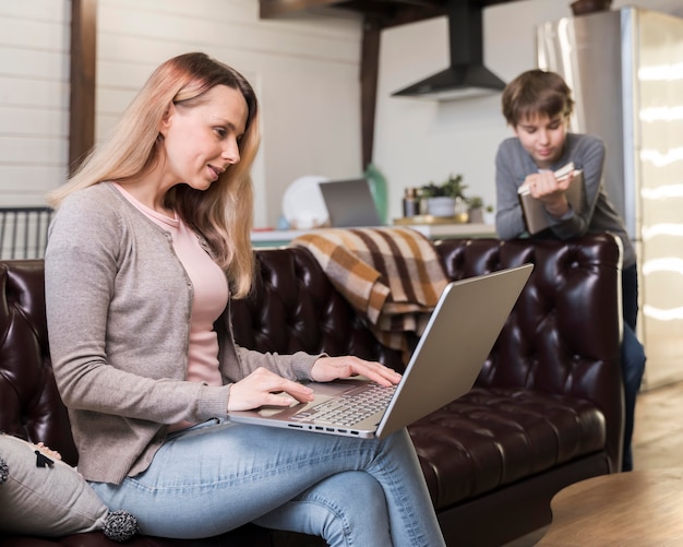 Mutter arbeitet fern auf der Couch