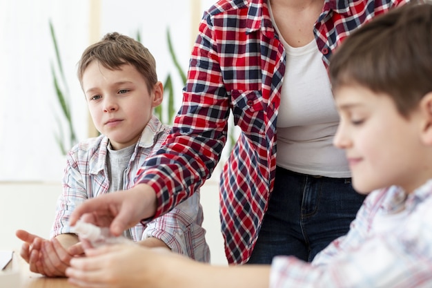 Mutter desinfiziert die Hände ihrer Kinder