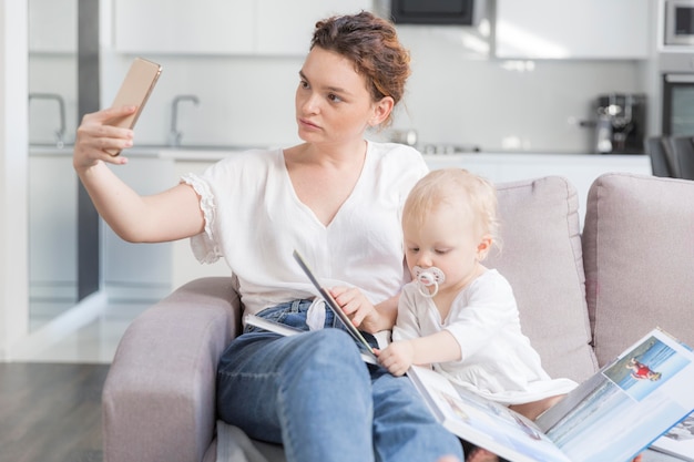 Kostenloses Foto mutter, die ein selfie mit niedlichem baby nimmt