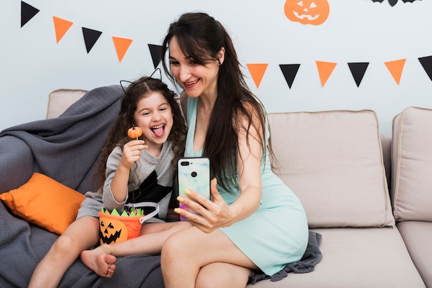Kostenloses Foto mutter, die ein selfie mit tochter an halloween nimmt