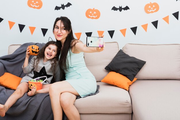 Mutter, die ein selfie mit Tochter an Halloween nimmt