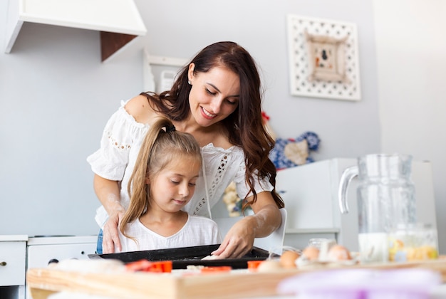 Mutter, die ihrer Tochter beibringt, wie man kocht