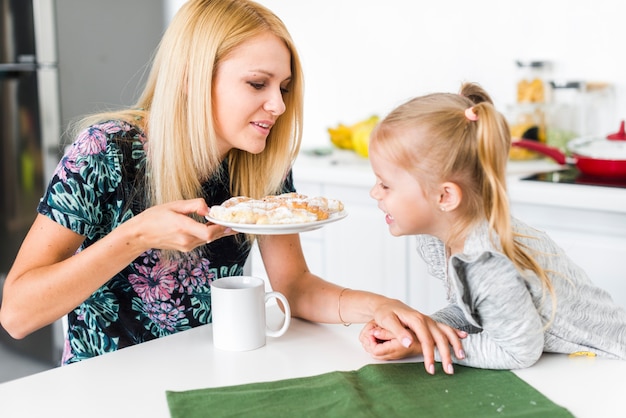 Mutter, die ihrer Tochter Snacks gibt