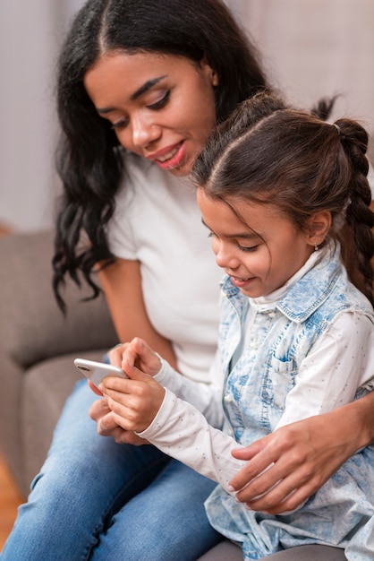 Mutter, die Kind auf Mobile spielen lässt