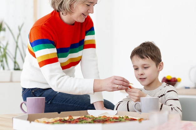 Mutter, die Kind Händedesinfektionsmittel gibt, bevor sie Pizza isst