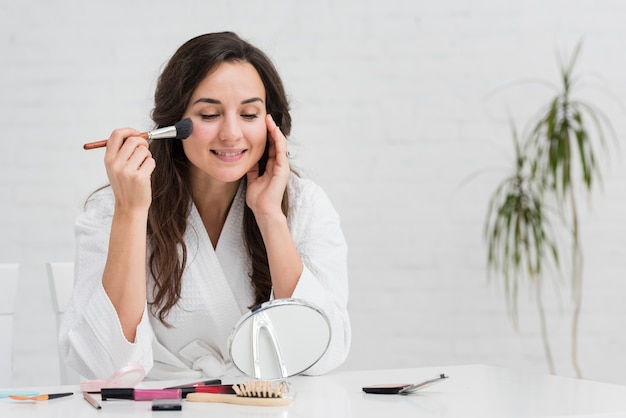 Mutter, die sich mit ihrem Make-up auf einen neuen Tag vorbereitet