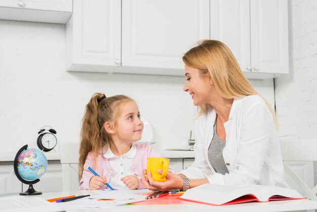 Mutter, die Tochter bei ihren Hausaufgaben hilft