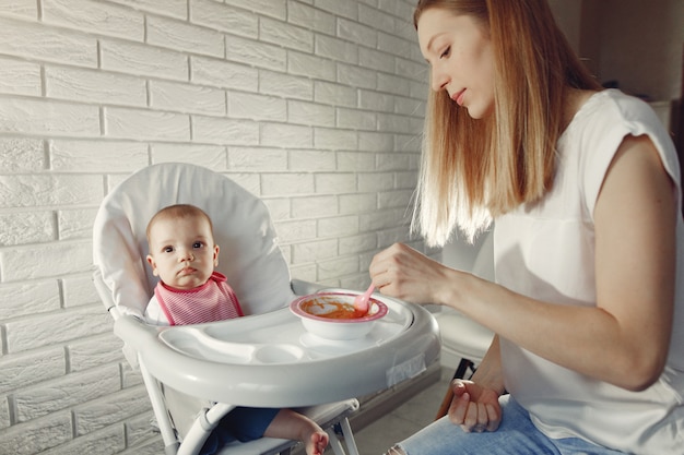 Mutter füttert ihr kleines Baby in einer Küche