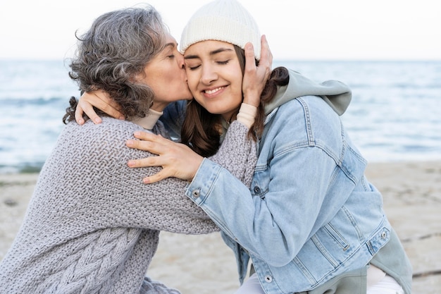 Mutter hat einen zärtlichen Moment mit Tochter am Strand