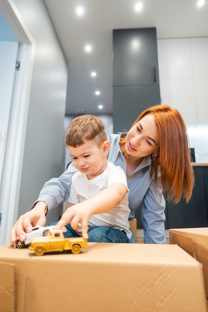 Mutter, kleiner Sohn spielen mit einem Spielzeug im Haus