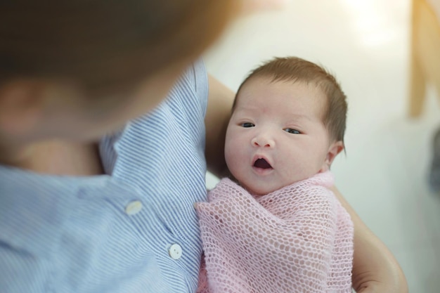 Mutter kümmert sich sorgfältig um ihr entzückendes neugeborenes Baby