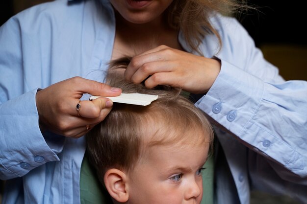 Mutter kümmert sich um ihr Kind mit Läusen