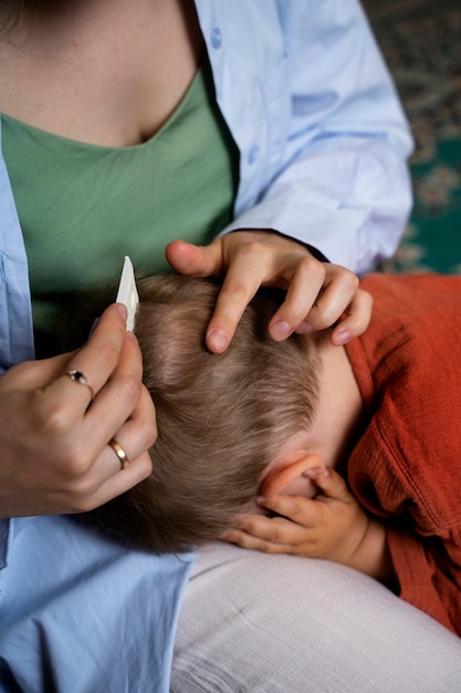 Mutter kümmert sich um ihr Kind mit Läusen