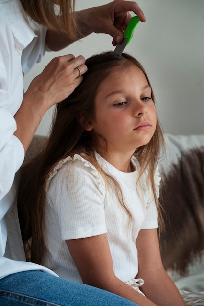 Kostenloses Foto mutter kümmert sich um ihr kind mit läusen