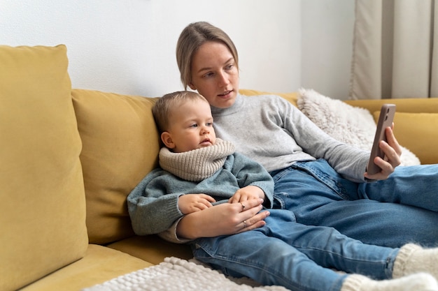 Mutter kümmert sich um ihr Kind und telekonsultiert mit dem Arzt