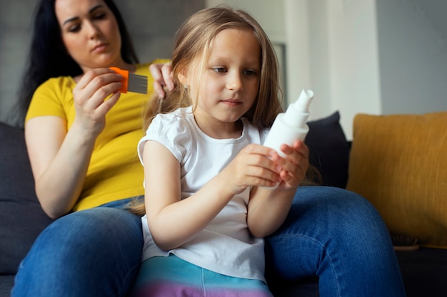 Mutter kümmert sich um Kind mit Kopfläusen